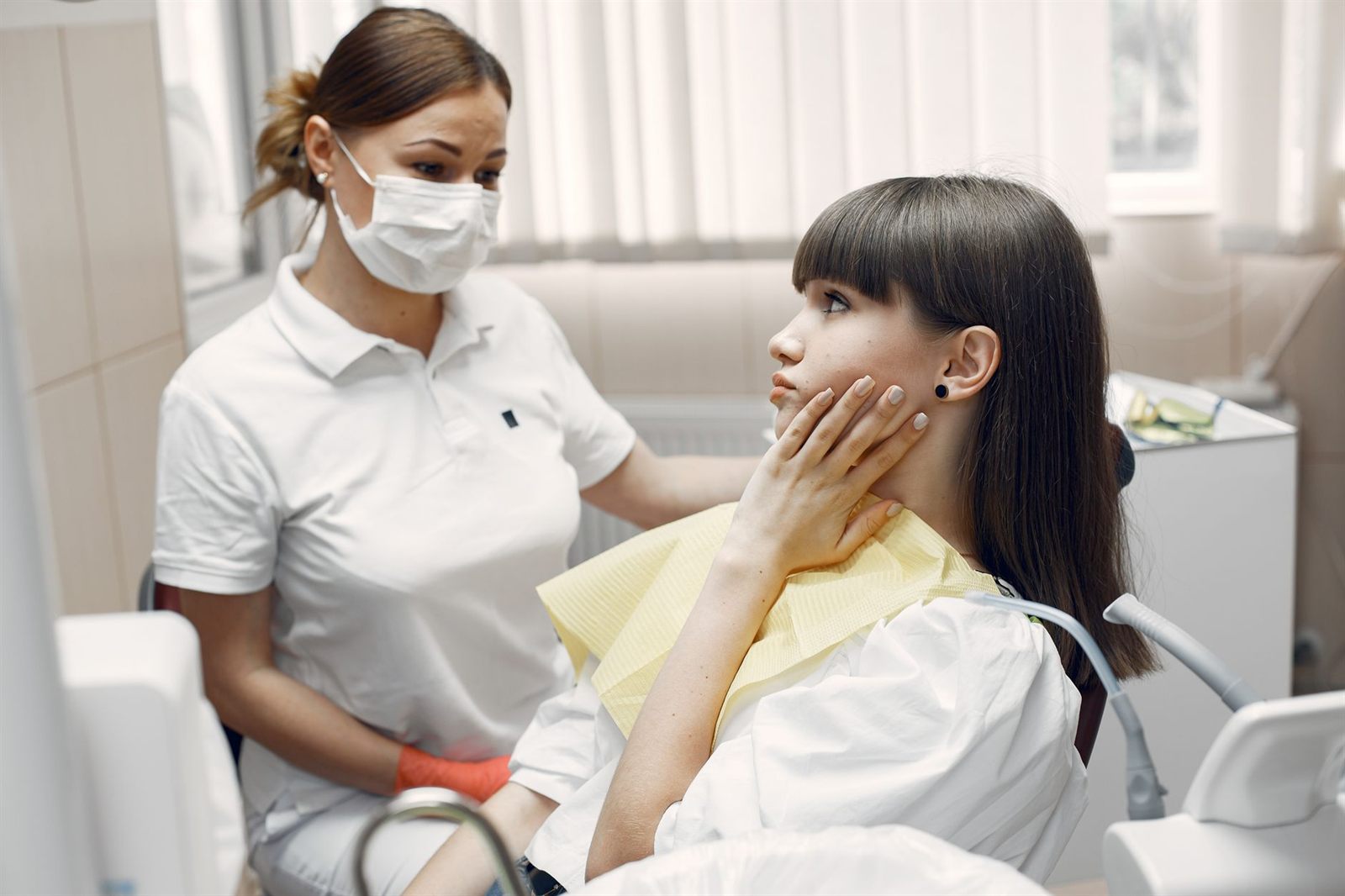 치과 진료실에서 치과의사가 환자의 치아 상태를 살펴보며 상담하는 모습 — 임플란트 진료·상담 장면